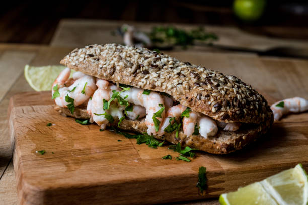 istock Shrimp Sandwich with lime on wooden surface. 833889406