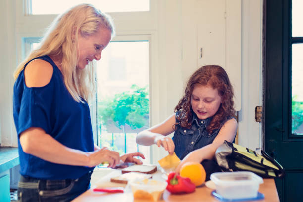 istock Mother and daughter making lunch on school morning. 833894616