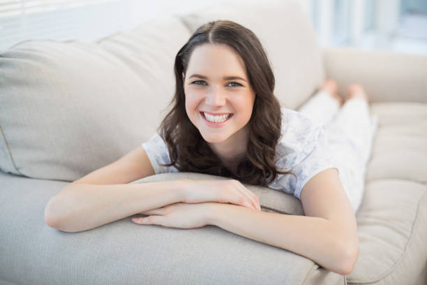 istock Cheerful pretty woman lying on a cosy couch 833896596