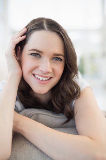 istock Close up on smiling cute woman lying on a cosy couch 833896836