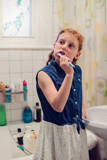istock Young redhead girl brushing teeth on school morning. 833913702