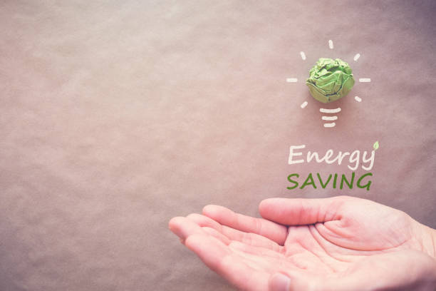 istock Green paper light bulb with Energy saving over hands, eco energy saving concept 833989470