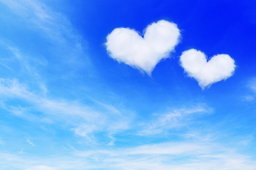 it is two heart shaped clouds on blue sky for valentine background.