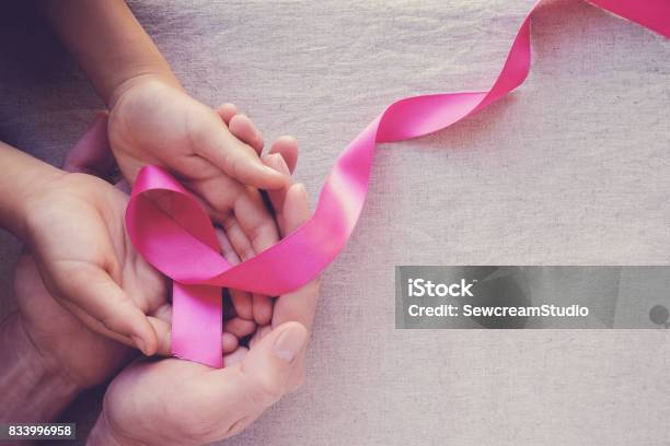 Adult And Child Hands Holding Pink Ribbons Breast Cancer Awareness Abdominal Cancer Awareness And October Pink Background Stock Photo - Download Image Now
