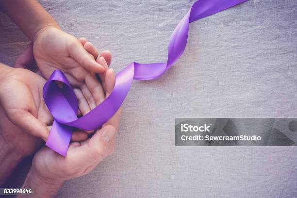 Hands Holding Purple Ribbons Toning Copy Space Background Alzheimer Disease Pancreatic Cancer Epilepsy Awareness Domestic Violence Wareness Stock Photo - Download Image Now