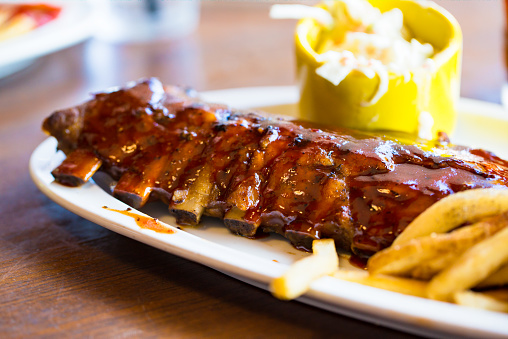 Full Rack Of Rib BBQ On White Plate With French Fried And Salad
