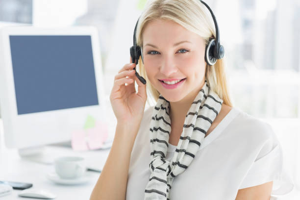 istock Smiling casual young woman with headset in office 834036370