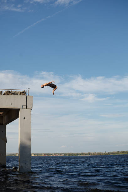 istock Man jumping into sea from pier 834060140