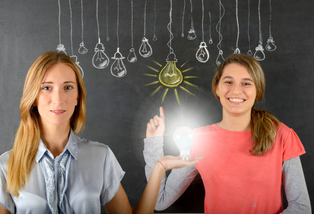 istock Two women and big idea light bulb 834086946