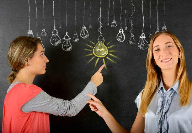 istock Two women and big idea light bulb 834087372