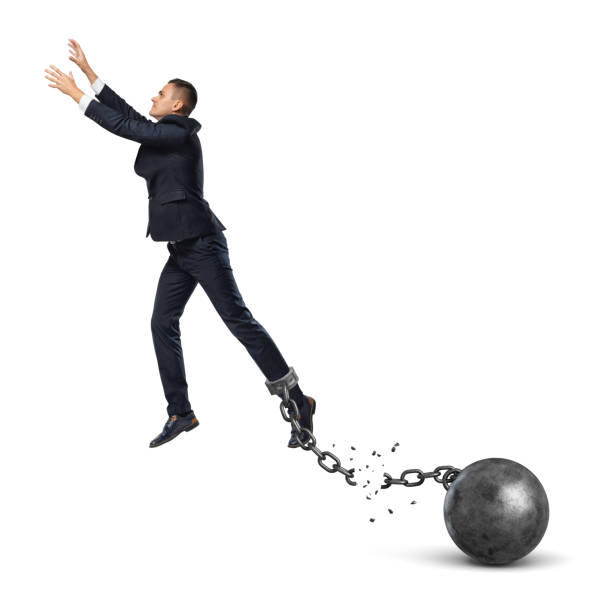 A businessman leaping away from an attached iron ball with a broken chain A businessman leaping away from an attached iron ball with a broken chain. Avoiding trouble. Credit refinancing. Business burdens. dragging photos stock pictures, royalty-free photos & images