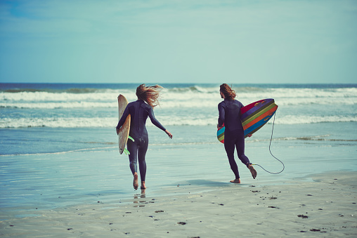 Shot of a young couple surfing at the beach