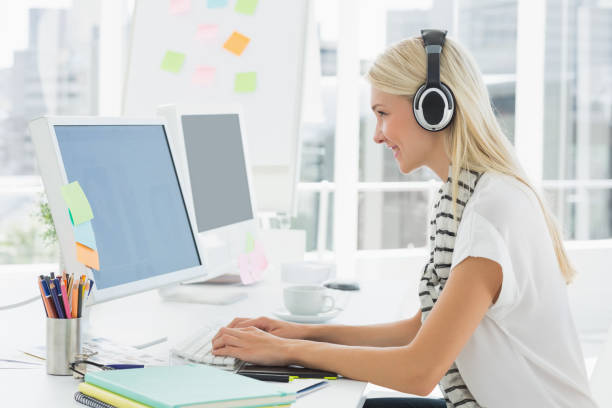 istock Casual young woman with headset using computer in office 834142440