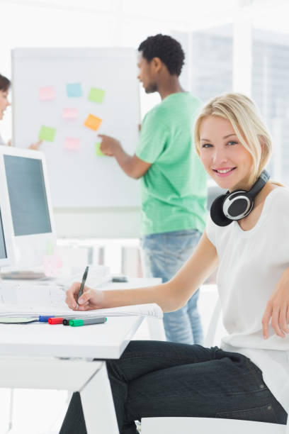istock Artist drawing something on paper with colleagues behind at office 834149604