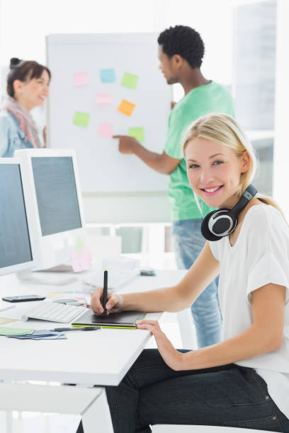 istock Artist drawing something on graphic tablet with colleagues behind 834149996