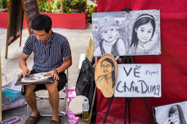 The man artist at spring fair on happy new year Hochiminh city, Vietnam - Jan 26 2017: Caricature Artist drawing in district 1. Artists line the resort during the summer for tourists to take back as souvenirs. vietnamese old man portrait stock pictures, royalty-free photos & images
