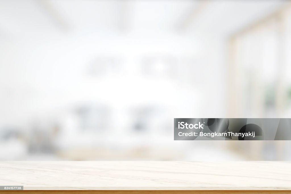 Empty marble table with blurred modern kitchen room background. Empty marble table with blurred modern kitchen room background. for product display montage. Front View Stock Photo