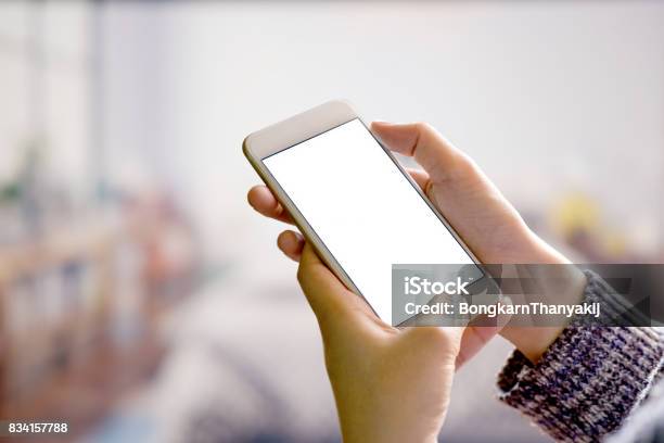 Woman Using Smartphone In Blurred Bedroom Background Stock Photo - Download Image Now