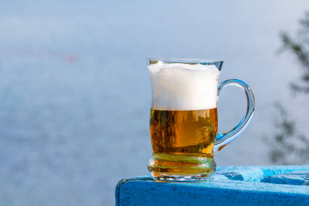istock Mug of beer on the table by the lake 834190924