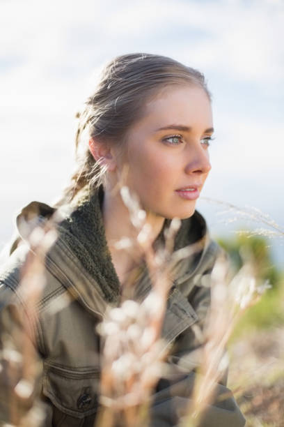 istock Beautiful woman sitting in grass 834191392