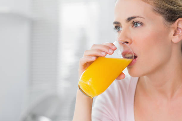 istock Thoughtful blond woman drinking orange juice 834203570