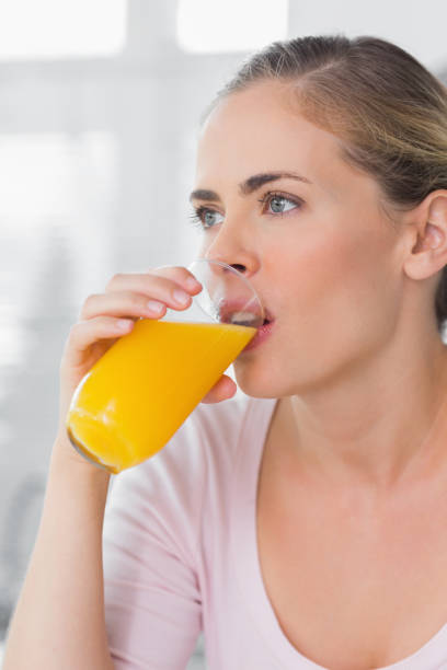 istock Thoughtful woman drinking orange juice 834203888