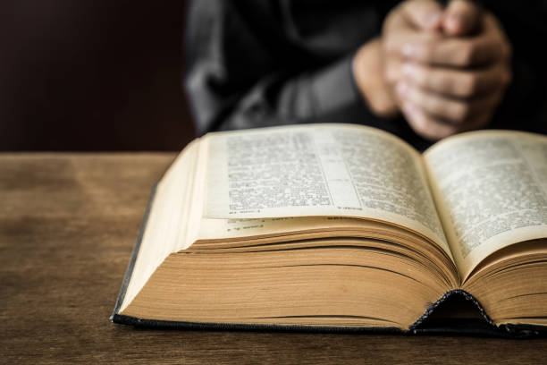 istock Opened bible in the quiet, dark atmosphere. Prayer time on sunday. 834244776
