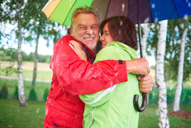 istock Couple standing and embrancing under umbrella 834256392