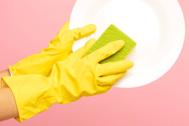 istock Hands in yellow protective gloves washing a plate 834302666
