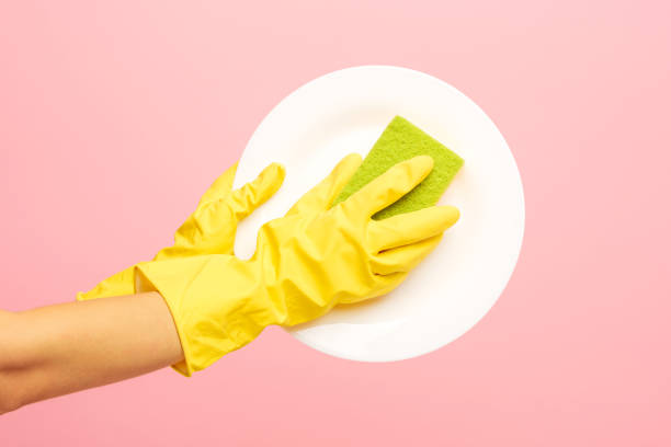 istock Hands in yellow protective gloves washing a plate 834302764
