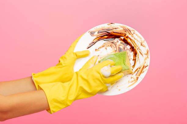istock Hands in yellow protective gloves washing a plate 834306630