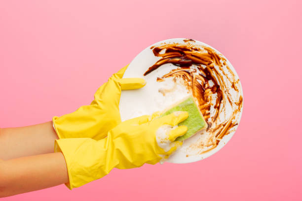 istock Hands in yellow protective gloves washing a plate 834306702
