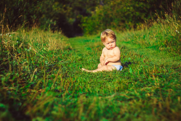 istock The child is sitting on the grass 834312548