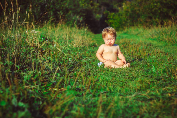 istock The child is sitting on the grass 834312666