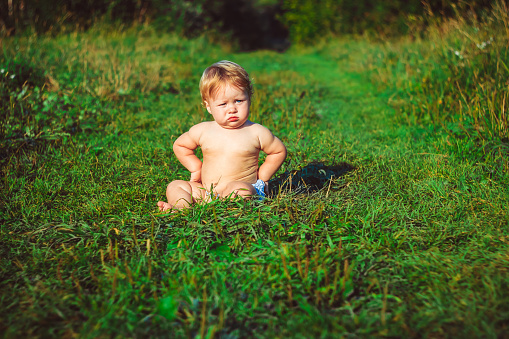 Little boy in a field praying.