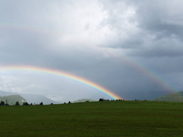 istock Alpine landscape with beautiful rainbow. Mountains, meadows and pastures with sunbow. 834313914