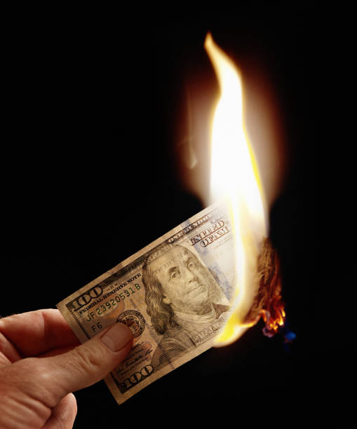istock Female hand holds burning US Hundred Dollar banknote 834314812