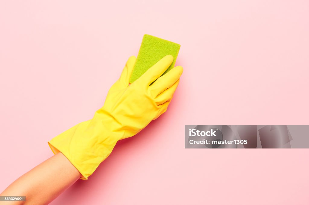 The woman's hand cleaning on a pink background. Cleaning or housekeeping concept The woman's hand cleaning on a pink background. Cleaning or housekeeping concept background. Frame for text or advertising Cleaning Stock Photo