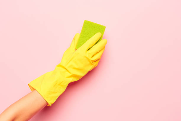 mão da mulher de limpeza em um fundo rosa. limpeza ou conceito de limpeza - kitchen glove - fotografias e filmes do acervo