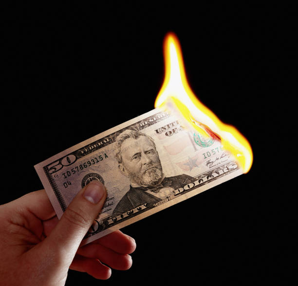 istock Burning $50 banknote held by female hand 834329328