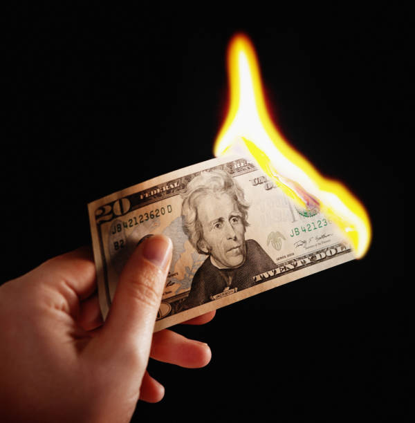 istock Female hand holds burning US Twenty Dollar banknote 834329944