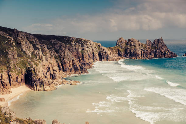Views over Pedn Vounder Beach towards Logan's Rock, South Cornwall on a bright June day.