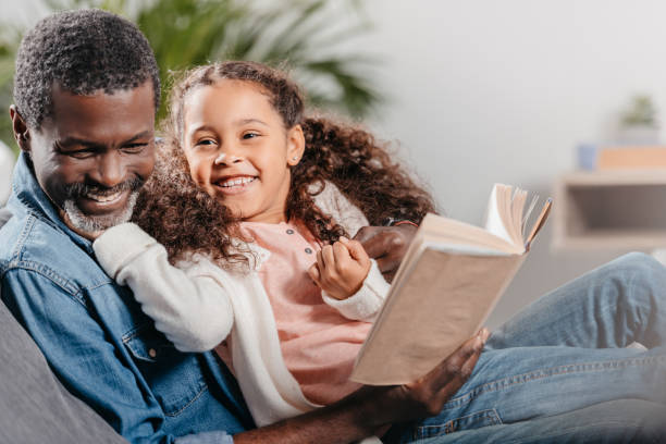 istock man reading book with daughter at home 834337010
