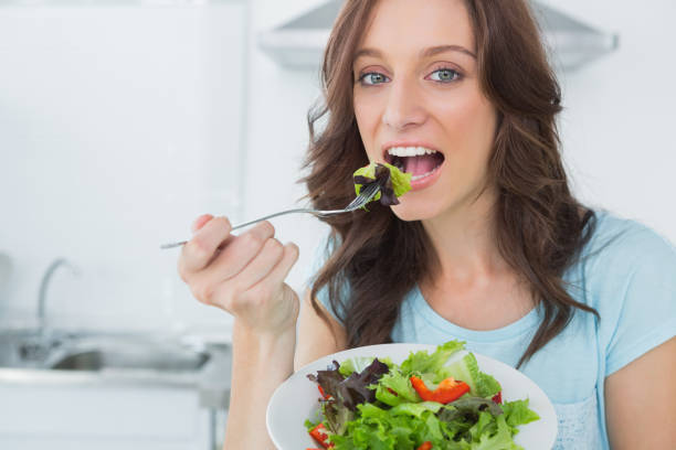 istock Brunette eating healthy salad 834343942