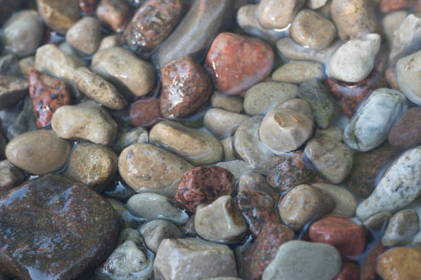 istock pebble stones in water background 834367428