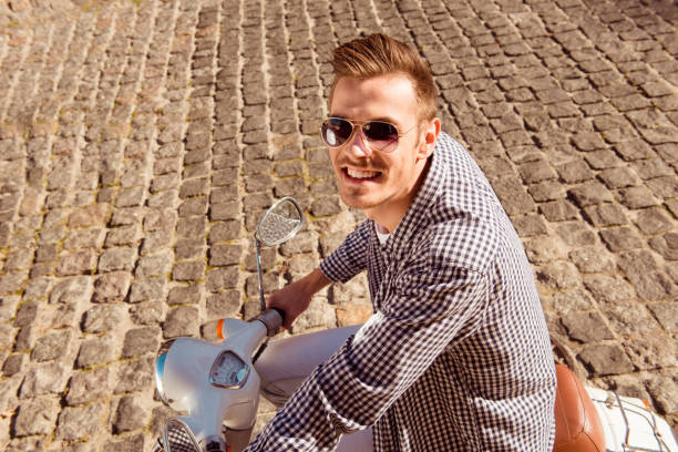 istock Cheerful handsome young man riding the motorbike 834371588