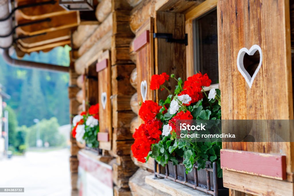 Typisch bayerische oder österreichische Holzfenster mit roten Geranien Blumen am Haus in Österreich oder Deutschland - Lizenzfrei Österreich Stock-Foto