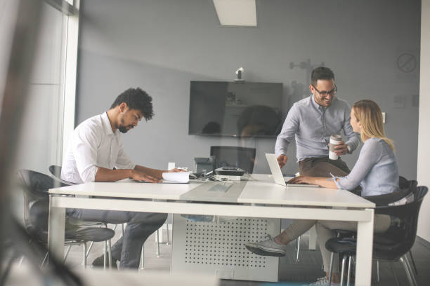 istock Three business people working in office.  Two colleague having conversation. 834384074