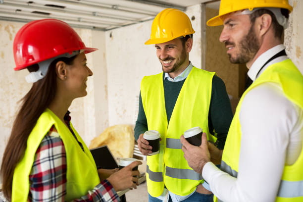 istock Group of architects talking on coffee break at construction site 834387364