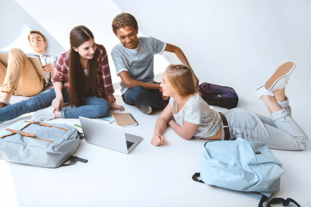 istock multicultural teenagers spending time together with laptop isolated on white 834395914
